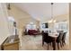 Open living and dining area with vaulted ceiling, large windows, and staircase with white railing at 877 Scrub Jay Way, Davenport, FL 33896