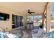Relaxing screened-in patio with comfortable seating, a ceiling fan, and views of the backyard, perfect for outdoor living at 877 Scrub Jay Way, Davenport, FL 33896