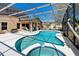 Beautiful pool with a spa surrounded by a screened-in patio, and lush landscaping, creating a private backyard retreat at 877 Scrub Jay Way, Davenport, FL 33896