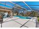 Resort-style pool with a spa, screened-in enclosure, and a covered patio, offering the ultimate outdoor entertaining space at 877 Scrub Jay Way, Davenport, FL 33896