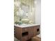 Elegant bathroom with a decorative mirror, mosaic tile wall, and a stylish wood vanity at 900 Golfview St, Orlando, FL 32804