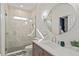 Bright bathroom featuring a tiled shower with glass door and a stylish vanity with a round mirror at 900 Golfview St, Orlando, FL 32804