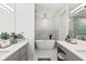 Bright bathroom featuring and sinks and a soaking tub with a chandelier at 900 Golfview St, Orlando, FL 32804