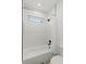 Clean and modern bathroom with a tub-shower combo and white geometric tile extending to the ceiling at 900 Golfview St, Orlando, FL 32804