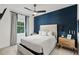 Bedroom with a large window, a navy blue accent wall, and neutral bedding for a calming retreat at 900 Golfview St, Orlando, FL 32804