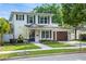 Charming two-story home with a well-manicured lawn, brick pathway, and a two car garage at 900 Golfview St, Orlando, FL 32804