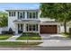 Charming two-story home with a well-manicured lawn, brick pathway, and a two car garage at 900 Golfview St, Orlando, FL 32804