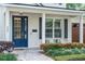 Charming front porch with a blue door, beautiful landscaping, and a welcoming seating area at 900 Golfview St, Orlando, FL 32804