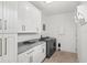 Modern laundry room with white cabinetry, gray countertops, and stainless steel appliances at 900 Golfview St, Orlando, FL 32804