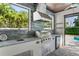 Well-equipped outdoor kitchen with a stainless steel grill, sink, and mini-fridge at 900 Golfview St, Orlando, FL 32804
