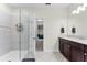 An open doorway reveals the bathroom, complete with a tiled walk-in shower and dark wood vanity at 10078 Greenshire Way, Orlando, FL 32827