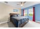 This bedroom features calming blue walls, sheer curtains, and a comfortable bed to offer a tranquil retreat at 10078 Greenshire Way, Orlando, FL 32827