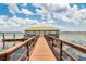 Picturesque view of a wooden dock and a covered pavilion extending into a serene lake at 10078 Greenshire Way, Orlando, FL 32827