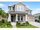 Charming two-story home with manicured lawn and a two-car garage under a bright blue sky at 10078 Greenshire Way, Orlando, FL 32827