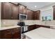 Well-equipped kitchen with stainless steel appliances, tiled backsplash, and modern fixtures at 10078 Greenshire Way, Orlando, FL 32827