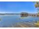 Picturesque lake featuring a serene dock with a covered pavilion, under a clear blue sky at 10078 Greenshire Way, Orlando, FL 32827