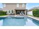A spacious pool with a spa, complemented by a covered patio featuring a bar area for entertaining at 10078 Greenshire Way, Orlando, FL 32827