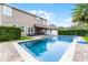 An outdoor pool with a spa, alongside a covered patio with a bar, offers a luxurious outdoor living space at 10078 Greenshire Way, Orlando, FL 32827