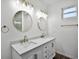 Bathroom features a double sink vanity with modern fixtures, round mirrors and plenty of counter space at 1070 Lake Ariana Blvd, Auburndale, FL 33823