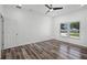 This bedroom has a ceiling fan, wood-look flooring and a lake view at 1070 Lake Ariana Blvd, Auburndale, FL 33823