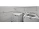 Well-equipped laundry room with washer, dryer, wire shelving, and ample space for storage at 1070 Lake Ariana Blvd, Auburndale, FL 33823