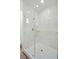 Walk-in shower features elegant marble walls, glass doors, gold fixtures and a shower bench at 1070 Lake Ariana Blvd, Auburndale, FL 33823
