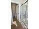 Bright bathroom features a shower and toilet, with tan tile flooring and an open doorway at 10711 Yellow Tiger Lily Dr # S, Orlando, FL 32832