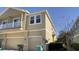 Multi-story home exterior features multiple garage doors and tan siding at 10711 Yellow Tiger Lily Dr # S, Orlando, FL 32832