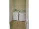 Functional laundry room features a washer and dryer with tiled floors and shelving at 10711 Yellow Tiger Lily Dr # S, Orlando, FL 32832