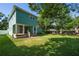 Expansive backyard featuring green grass, a covered porch, and mature trees at 1111 Guernsey St, Orlando, FL 32804
