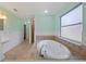 Bright bathroom with a jacuzzi bathtub, white fixtures, and aqua walls at 1111 Guernsey St, Orlando, FL 32804