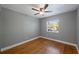 Bedroom with hardwood floors, gray walls, and ceiling fan with light fixture at 1111 Guernsey St, Orlando, FL 32804