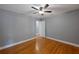 Bedroom features wood floors, gray walls, ceiling fan and a door to hallway at 1111 Guernsey St, Orlando, FL 32804