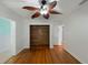 Bedroom featuring wood floors, a ceiling fan and closet with wooden paneling at 1111 Guernsey St, Orlando, FL 32804
