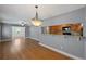 Open-concept dining area with hardwood floors and a passthrough to the kitchen, enhancing the flow of the space at 1111 Guernsey St, Orlando, FL 32804