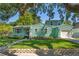 Charming two-story home featuring a well-maintained lawn, stone accents, and beautiful mature trees offering shade at 1111 Guernsey St, Orlando, FL 32804