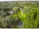 Expansive aerial view showcasing a lush, green property with a basketball court and a serene lake surrounded by trees at 117 Starling Ln, Longwood, FL 32779