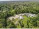 Aerial view of equestrian center featuring horse paddocks and stables, surrounded by lush greenery and mature trees at 117 Starling Ln, Longwood, FL 32779