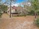 Rear exterior view of the home featuring a covered patio and natural landscaping at 117 Starling Ln, Longwood, FL 32779
