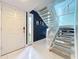 Inviting foyer featuring white tile flooring, a staircase with carpeted steps, and a modern design at 117 Starling Ln, Longwood, FL 32779