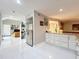 Open concept kitchen with stainless steel refrigerator, white cabinets, granite counters and tile flooring at 117 Starling Ln, Longwood, FL 32779