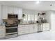 Well-lit kitchen featuring stainless appliances, white cabinetry, granite counters, and white tile flooring at 117 Starling Ln, Longwood, FL 32779