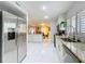 Bright modern kitchen with white cabinetry, stainless steel appliances, and an open view to the living room at 117 Starling Ln, Longwood, FL 32779