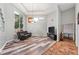 Bright living room featuring a tray ceiling, hardwood floors, and large windows at 12820 Butler Bay Ct, Windermere, FL 34786