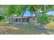 Backyard view showcasing mature trees and a screened-in lanai at 1420 Continental Dr, Daytona Beach, FL 32117