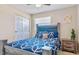 Cozy bedroom with natural wood headboard, blue bedding, and light hardwood floors at 1420 Continental Dr, Daytona Beach, FL 32117