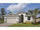 Charming single-Gathering home featuring a two-car garage, stone accents, and a well-manicured front lawn at 145 Old Moss Cir, Deland, FL 32724