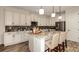 Modern kitchen featuring white cabinets, granite countertops, stainless steel appliances, and island seating at 145 Old Moss Cir, Deland, FL 32724