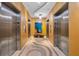 Modern elevator lobby with decorative flooring, wood paneling, and an art display at 150 E Robinson St # 2308, Orlando, FL 32801