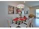 Chic dining area featuring modern art, pendant lighting, and a glass table for stylish entertaining at 1523 Still Dr, Clermont, FL 34714